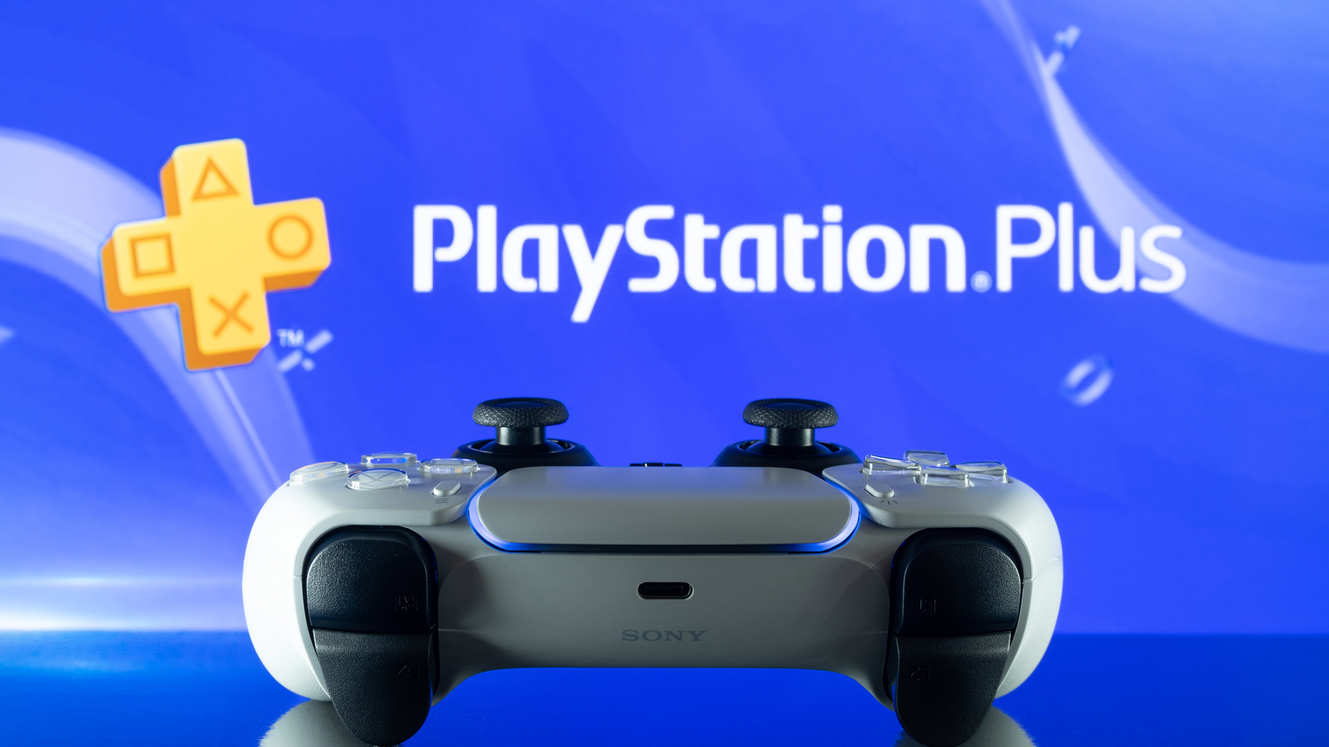 Controlador DualSense PS5 frente al logotipo de PlayStation Plus