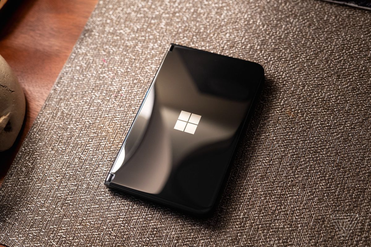 Microsoft Surface Duo 2 negro cerrado y sobre un colchón.