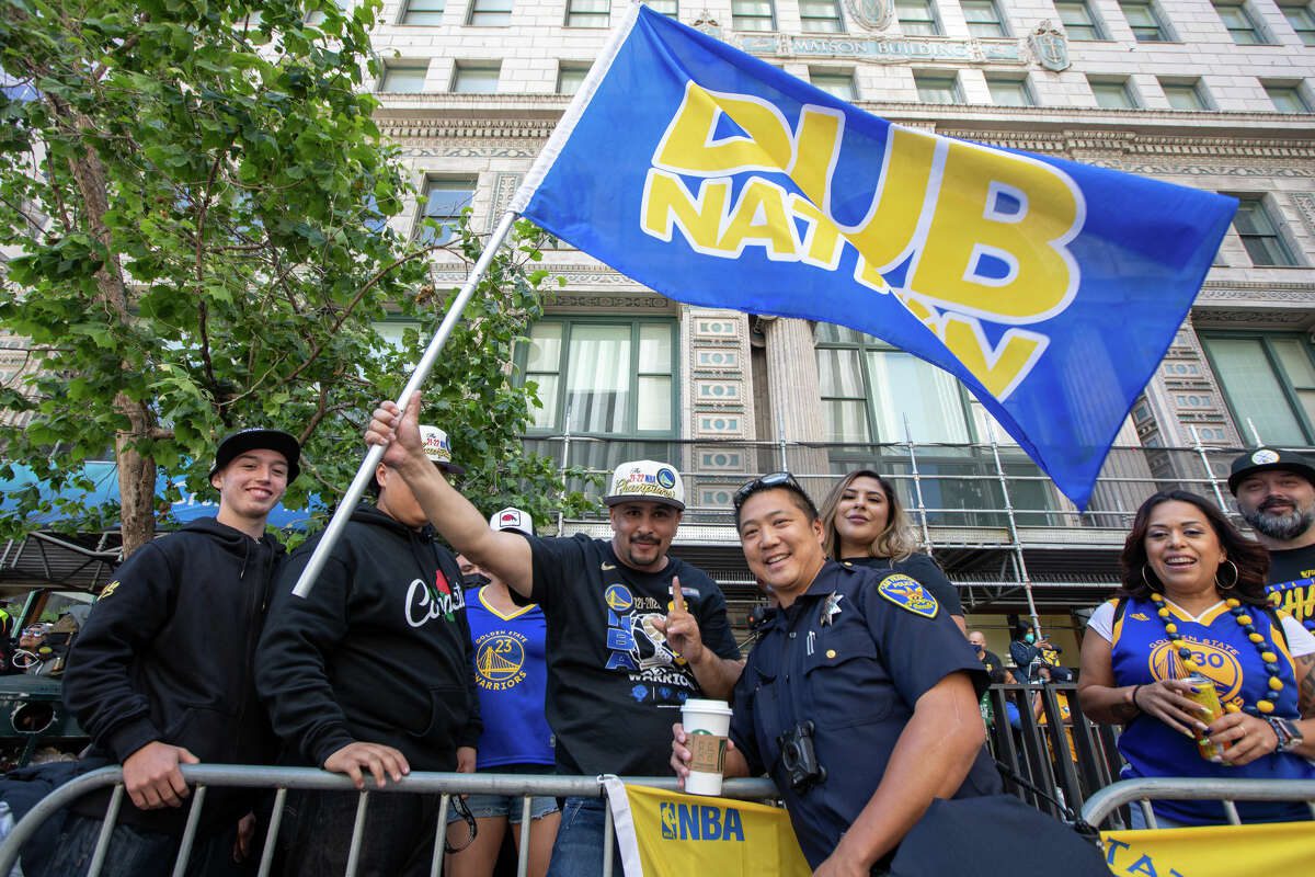 Un fanático sostiene la bandera de Dub Nation durante una revisión del Campeonato Golden State Warriors en Market Street en San Francisco, California, el 20 de junio de 2022.
