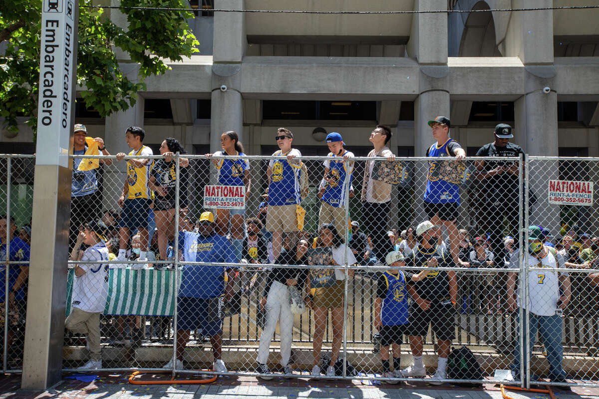 Los fanáticos se paran en las vías del tren para ver la acción durante el Desfile del Campeonato Golden State Warriors en Market Street en San Francisco, California, el 20 de junio de 2022.