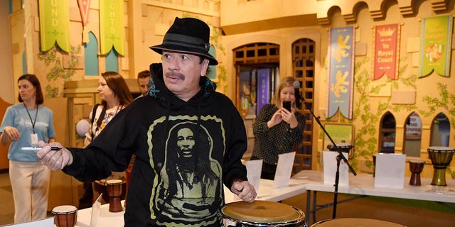 El artista Carlos Santana firma autógrafos del Congreso donados por él y su esposa Cindy Blackman Santana a la Filarmónica de Las Vegas mientras participaba en la versión global del programa de educación musical orKIDStra de la Orquesta Filarmónica para un grupo de estudiantes en el Children's Museum of Discovery el 29 de octubre de 2019 en Las Vegas, Nevada.