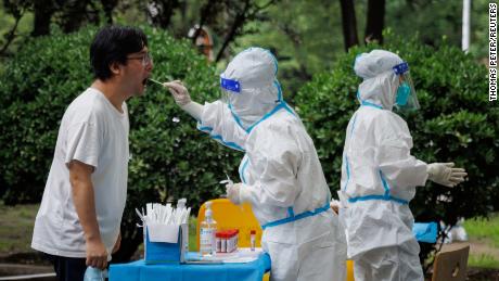 Un trabajador médico toma una muestra de hisopo en una estación de pruebas de ADN en Beijing el 6 de julio.