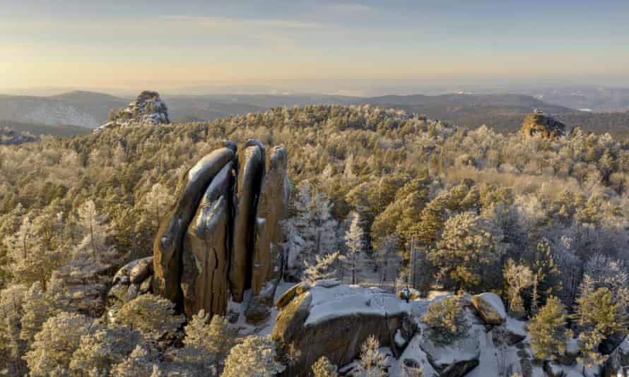 Formaciones rocosas cubiertas de nieve rodeadas de bosques