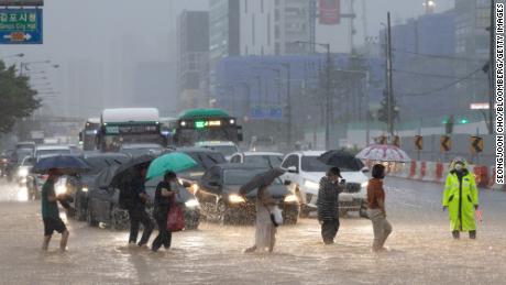 Los peatones cruzan una calle inundada en Gimpo, Seúl, el 9 de agosto.