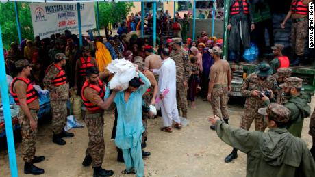 Las fuerzas del ejército distribuyen alimentos y suministros a las personas desplazadas en un campamento de socorro en el distrito de Jamshoro, al sur de Pakistán, el 24 de agosto.