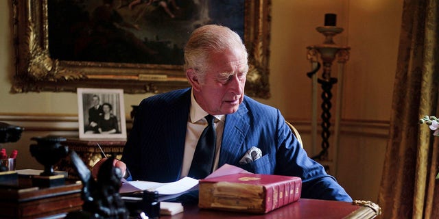 En esta foto del 11 de septiembre de 2022, el rey Carlos III de Gran Bretaña lleva a cabo deberes oficiales del gobierno desde su cofre rojo en la sala del siglo XVIII en el Palacio de Buckingham, Londres.  (Victoria Jones/PA vía AP)