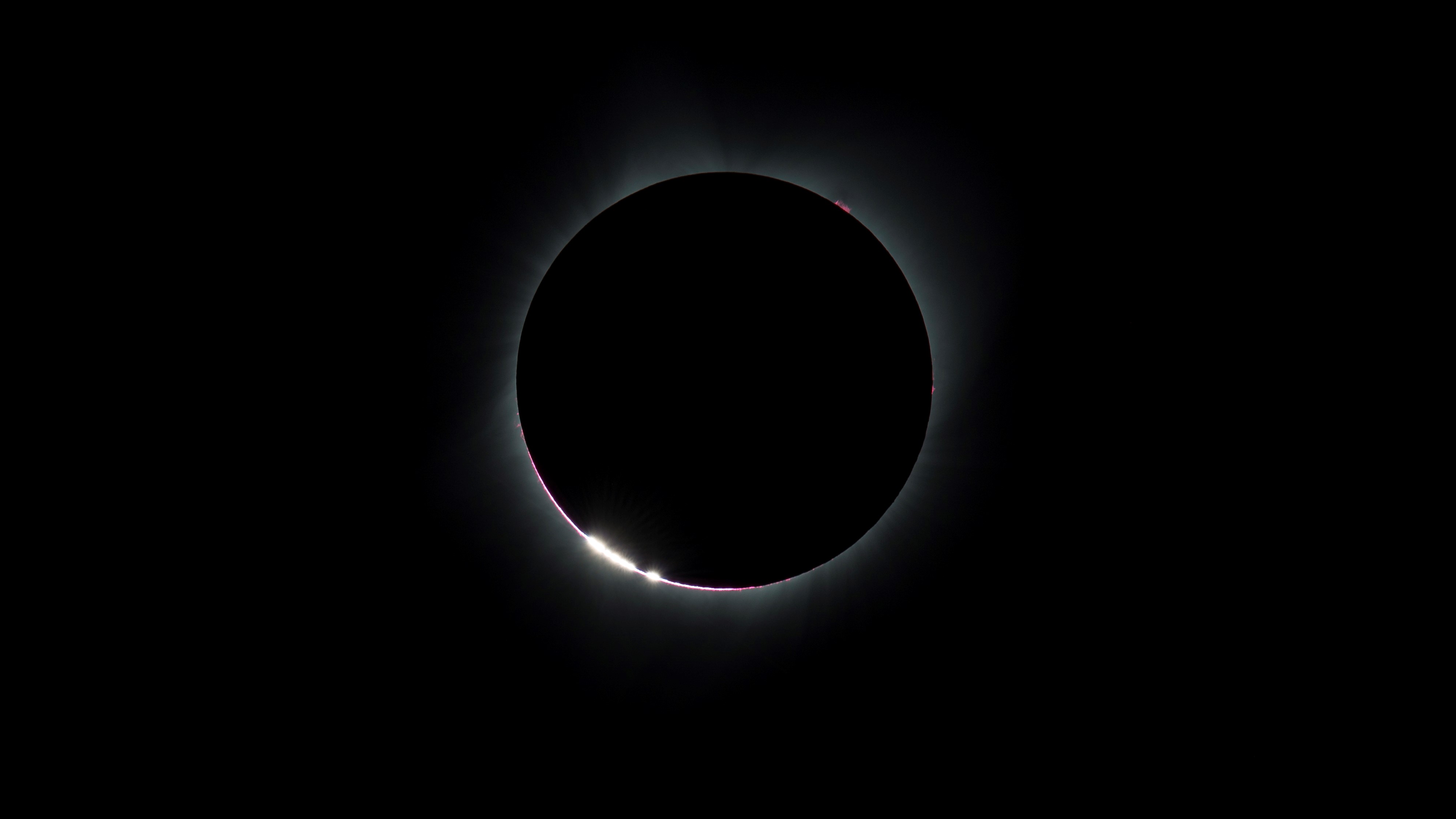 Se producen brillantes granos de luz alrededor del borde de un eclipse solar pre-total.
